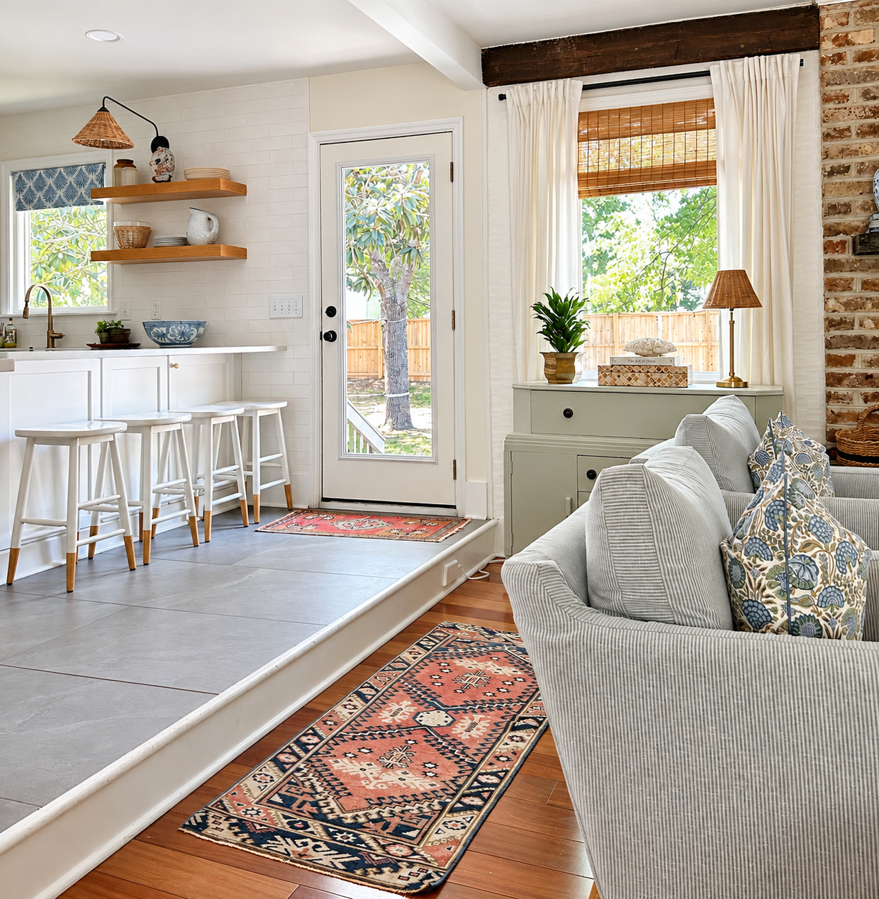 Layered kitchen and living space with woven lighting, blue patterned textiles, wood furnishings, and a vintage rug